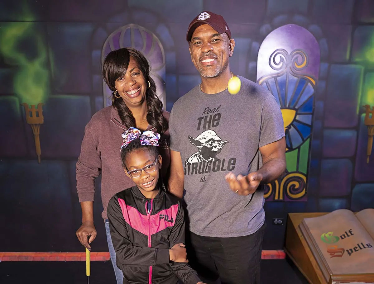 Happy Family Playing Mini Golf at Enchanted Castle